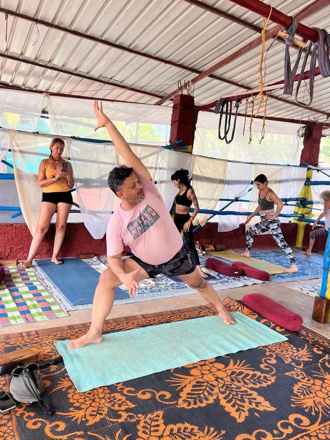 Alpesh Patwari demonstrating extended side angle pose to a standing class at the Arambol shala