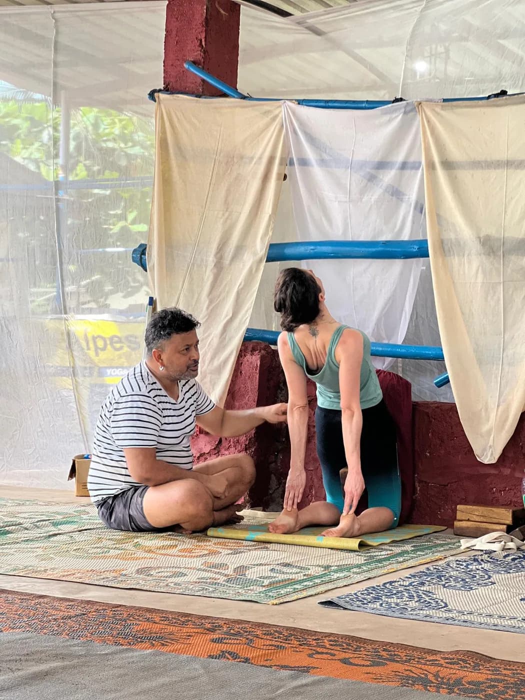 Alpesh Yoga teacher giving one-to-one guidance to a student on her mat