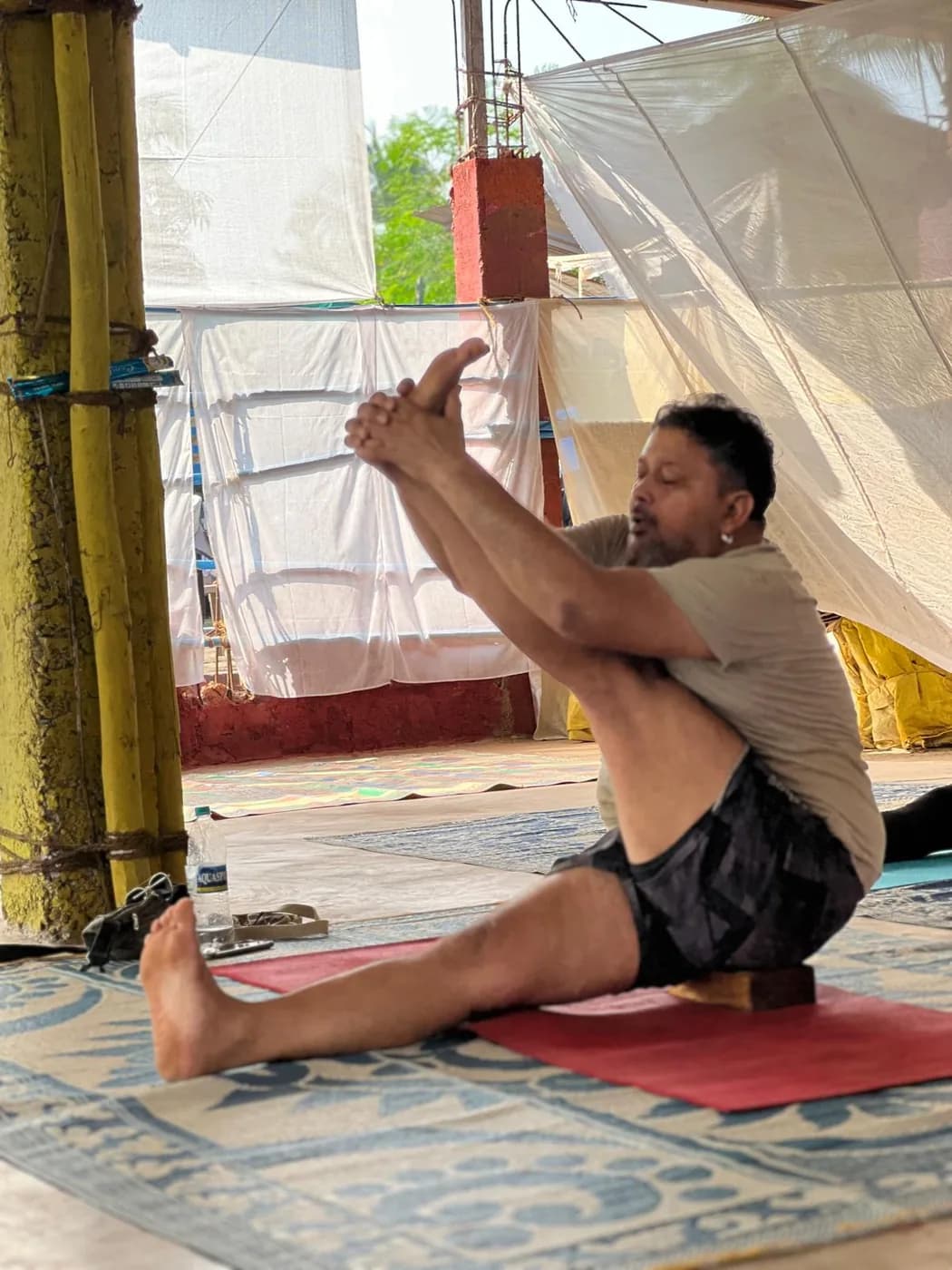Student sitting on a block to practise a seated compass pose during alignment training