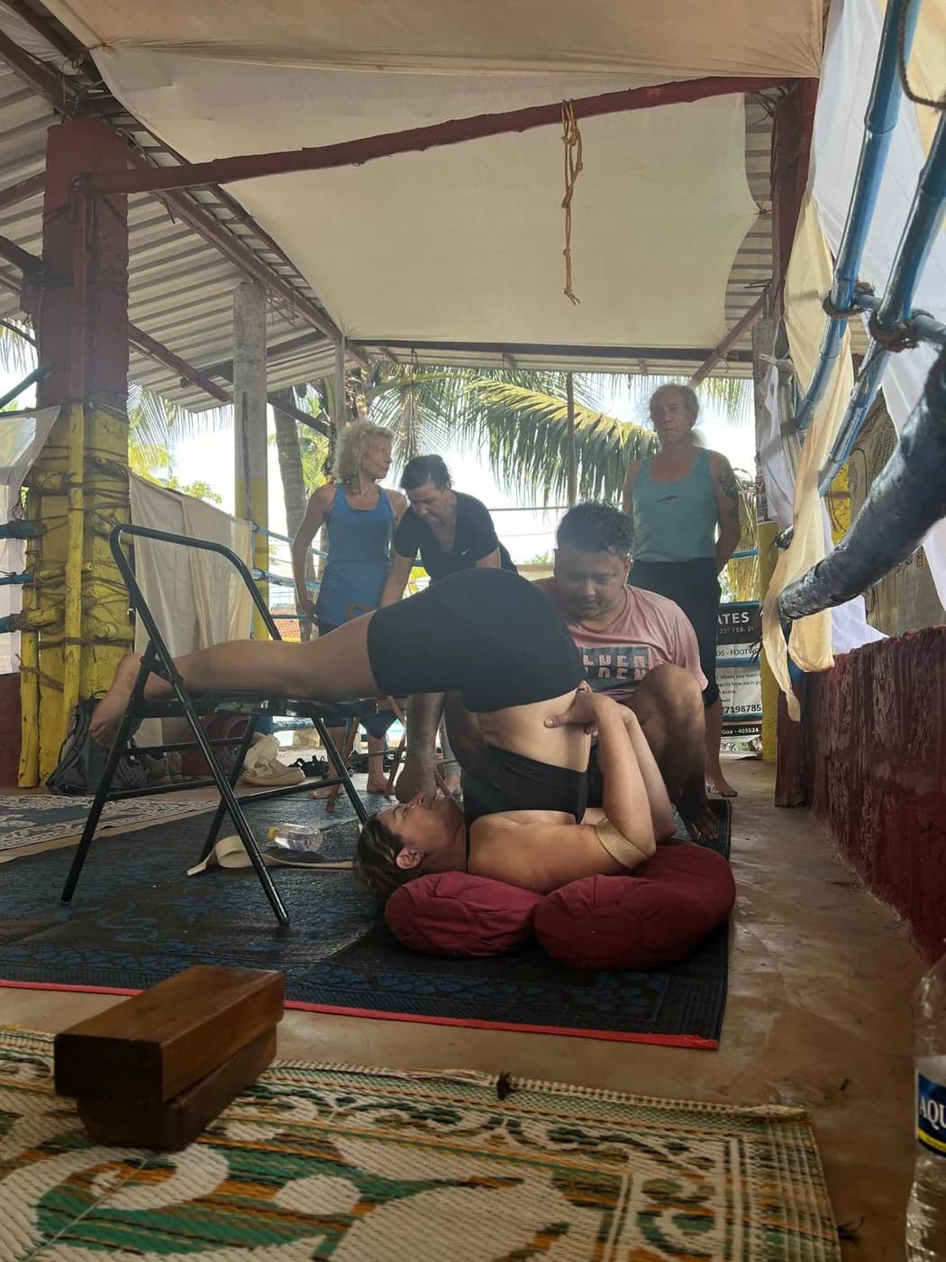 Yoga therapy session in progress at the shala while other students practise behind